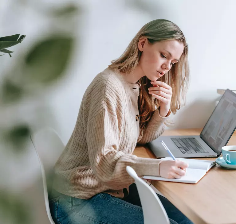 Žena si píše do zápisníka