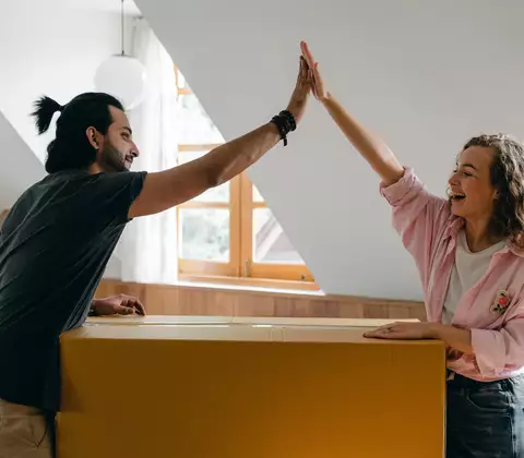 Žena a muž mají radost z dobře vykonané práce při stěhování