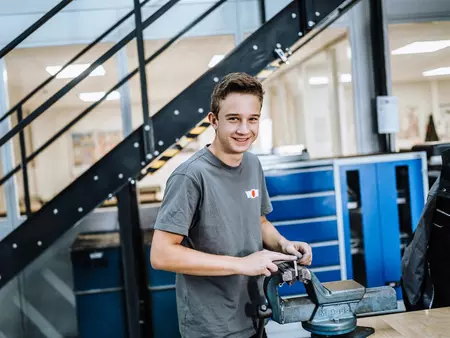 Feinwerkmechaniker der ein Stück Metall schleicht 