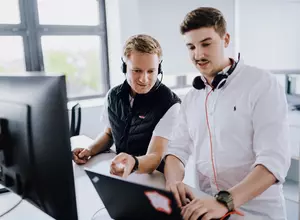Mitarbeiter mit Headset und Laptop beim Arbeiten