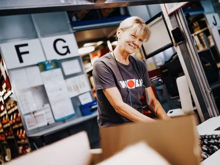 Bild einer Dame die am Verpacken von Kleinteilen ist 