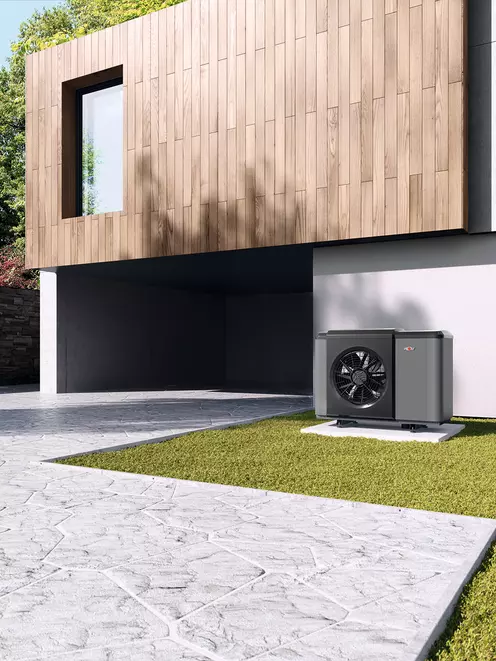 Eine WOLF Wärmepumpe neben der Einfahrt der Garage  