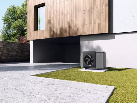 Eine WOLF Wärmepumpe neben der Einfahrt der Garage  