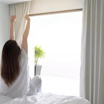 Frau streck sich im Bett