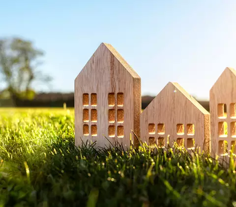Holzhaus-Modelle auf grüner Wiese