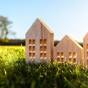 Holzhaus-Modelle auf grüner Wiese