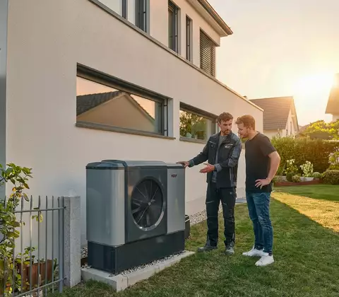 Zwei Männer im Garten vor Wärmepumpe CHA