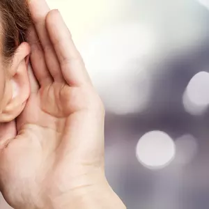 Eine Frau die mit ihrer Hand eine Hören bewegung macht 