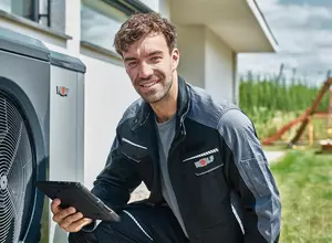 Fachhandwerker prüft Wärmepumpe bei dem Kunden
