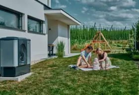 Leise WOLF Wärmepumpe Familie mit Baby im Garten neben Wärmepumpe