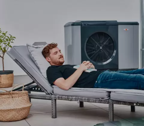 Mann schlafend im Garten vor Wärmepumpe 