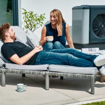 Zwei Menschen im Garten mit Wärmepumpe